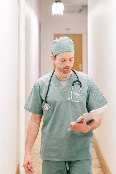 doctor-walking-down-hallway-with-clipboard